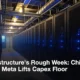Rows of server racks with blue lights inside a dim data center hall.