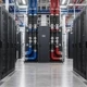 Data-center service aisle with server cabinets and liquid-cooling distribution equipment.
