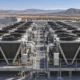 Rows of rooftop dry coolers, fans and pipes at a data center.