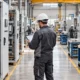 Rows of switchgear cabinets at different stages of factory assembly.