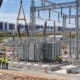Utility crew upgrading a high-voltage substation near data-center buildings.