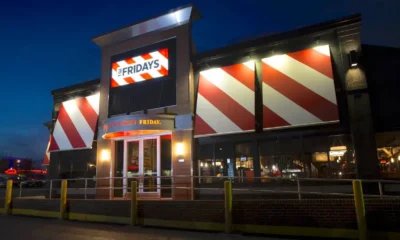 TGI Fridays restaurant exterior at night with its red-and-white striped facade