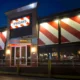 TGI Fridays restaurant exterior at night with its red-and-white striped facade